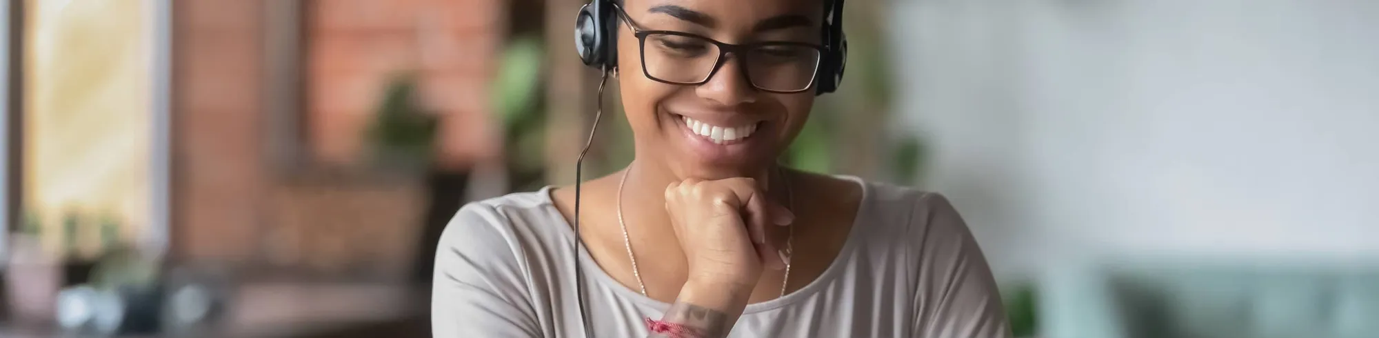 Woman with a headset sitting in front of a laptop