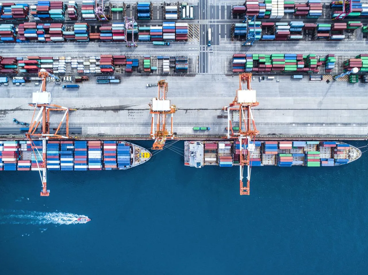 An areal view of two container ships docked in a container yard